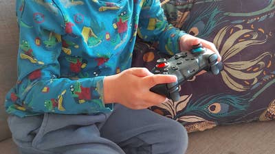 A child sitting on a couch holding a controller