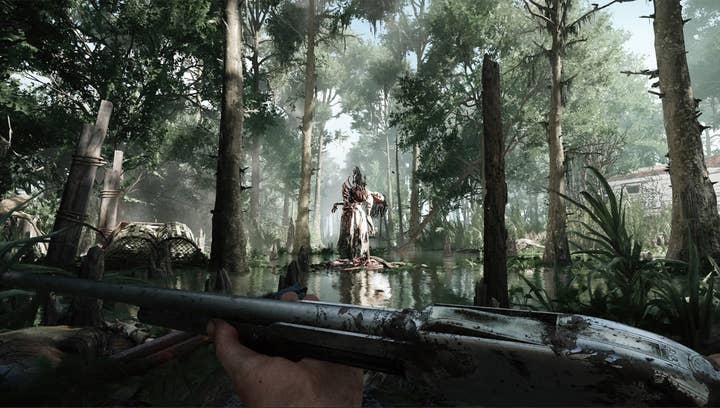 Hunt: Showdown screenshot shows first-person shooter view in a swamp where a monstrous women stands in a brightly lit clearing, bent backwards grotesquely with ribs jutting through her skin and something protruding skyward from her stomach
